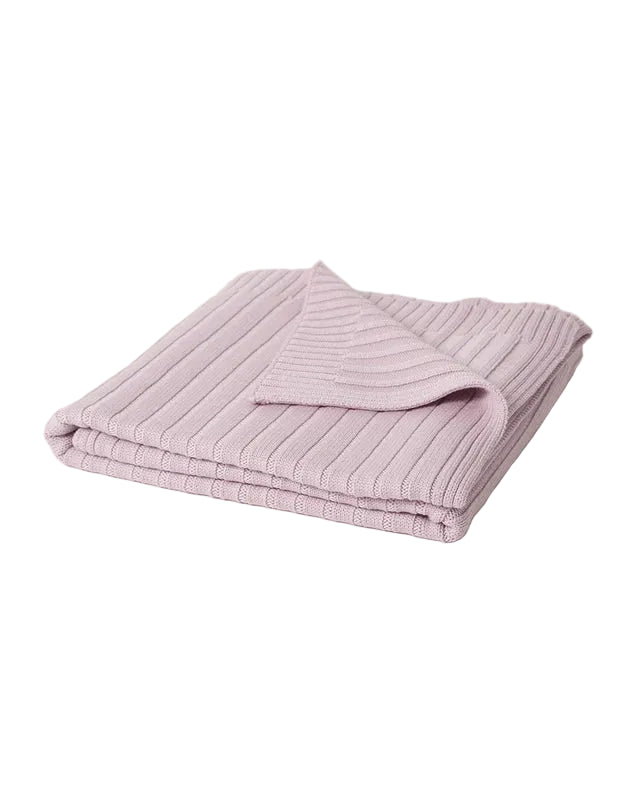 Folded pink ribbed 100% merino wool blanket on a light gray background