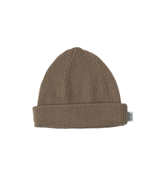 Brown 100% merino wool knit beanie with a small Babu brand tag on a light gray background