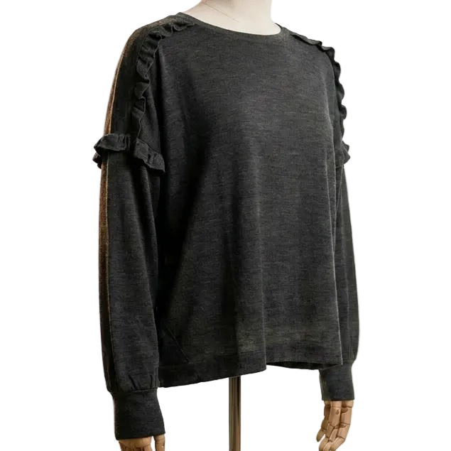 Mannequin wearing a dark grey merino wool womens sweater with frill detail in a photo studio setting with lighting equipment.