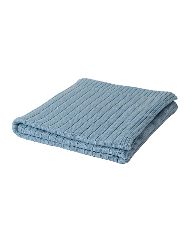 Folded blue 100% merino wool ribbed blanket on a light gray background