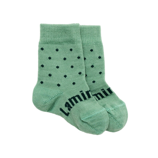 Pair of green baby merino wool socks with navy polka dots and 'lamington' branding on a white background
