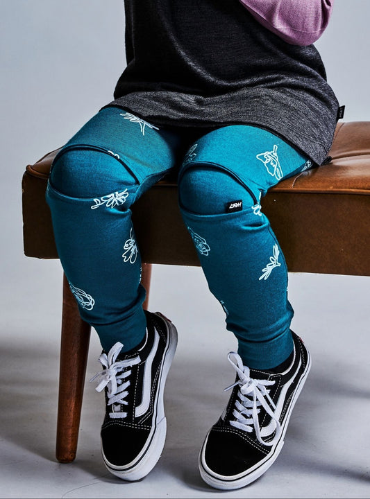 Child sitting on a stool wearing 100% merino wool leggings with subtle flower print